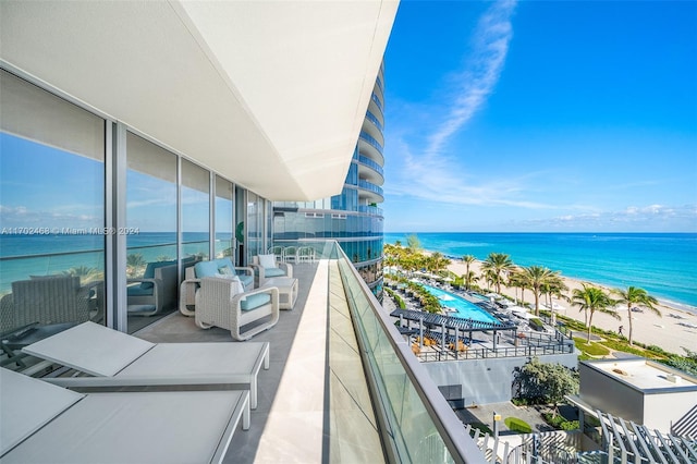 balcony featuring a water view and a beach view