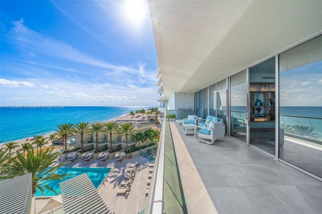 balcony with a water view and a view of the beach