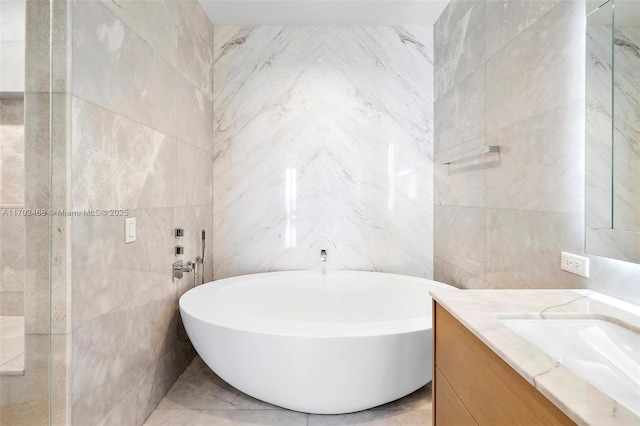 full bathroom with a soaking tub, tile walls, and vanity