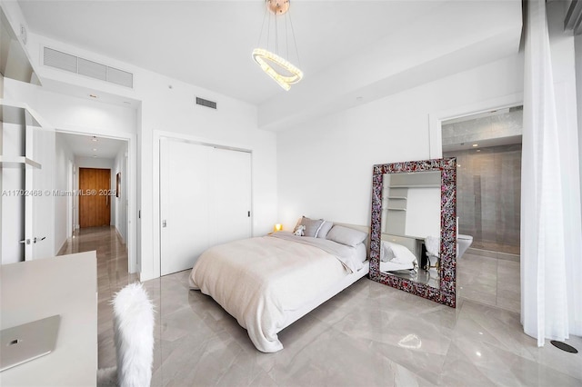 bedroom featuring a closet, visible vents, and ensuite bath