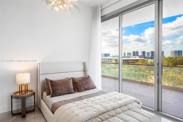 bedroom featuring a view of city, access to outside, multiple windows, and an inviting chandelier