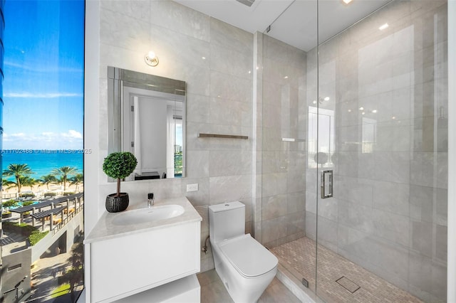 full bath featuring a shower stall, tile walls, toilet, and vanity