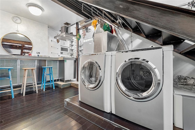 laundry room with dark hardwood / wood-style flooring and washer and dryer