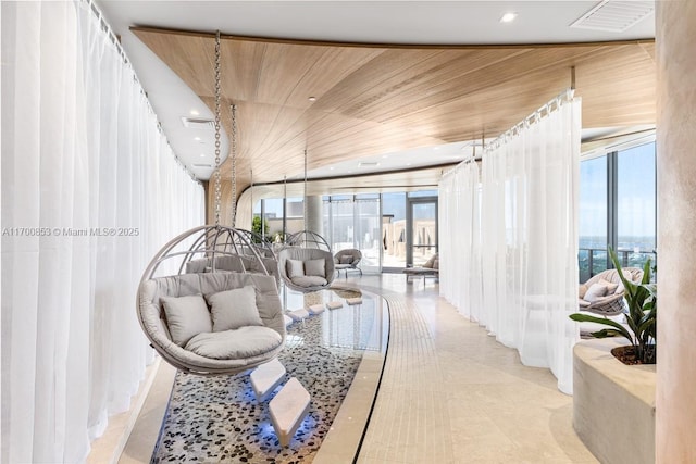 community lobby featuring plenty of natural light, light tile patterned floors, and wood ceiling