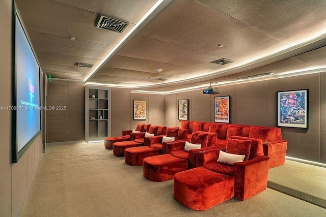 carpeted cinema room with a drop ceiling