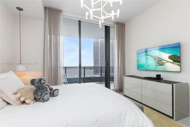 bedroom featuring floor to ceiling windows, a chandelier, and access to outside