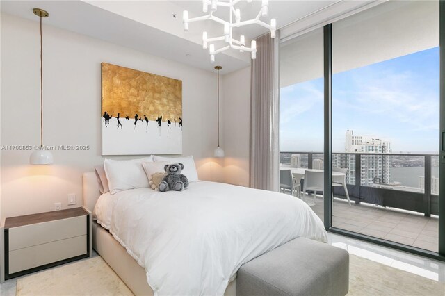 bedroom with floor to ceiling windows, access to exterior, and an inviting chandelier