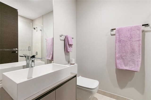 bathroom featuring vanity, toilet, and a shower with shower door