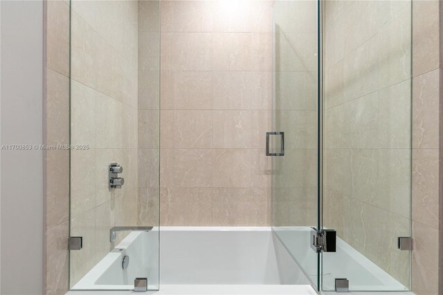 bathroom with shower / bath combination with glass door