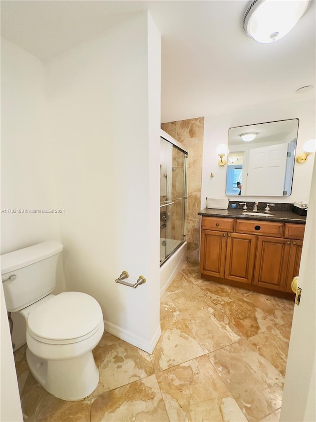 full bathroom with shower / bath combination with glass door, vanity, and toilet