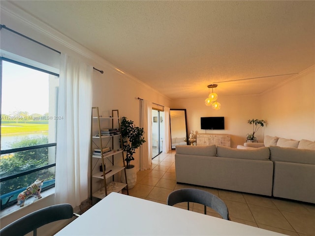 tiled living room with ornamental molding, a textured ceiling, a water view, and a healthy amount of sunlight