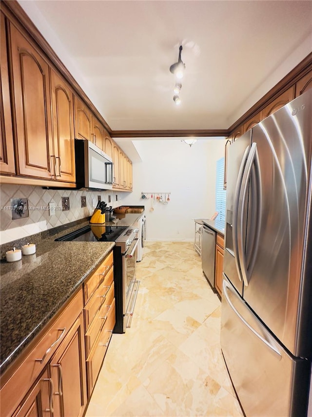 kitchen featuring dark stone countertops, appliances with stainless steel finishes, and tasteful backsplash