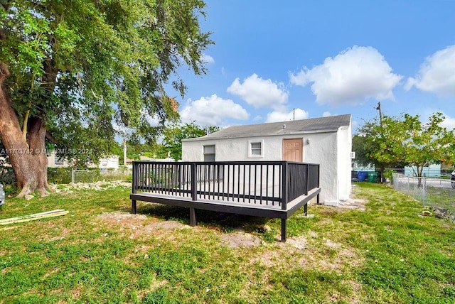 back of property featuring a lawn and a wooden deck