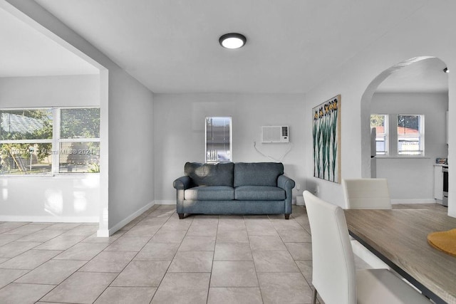 living room featuring light tile patterned floors and a wall mounted AC