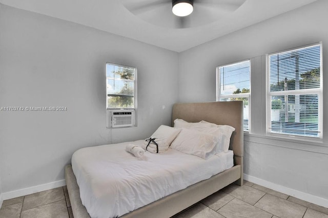 bedroom with ceiling fan, light tile patterned floors, and multiple windows