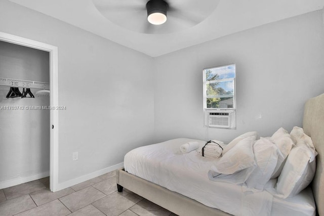 bedroom with light tile patterned floors, a closet, ceiling fan, and cooling unit