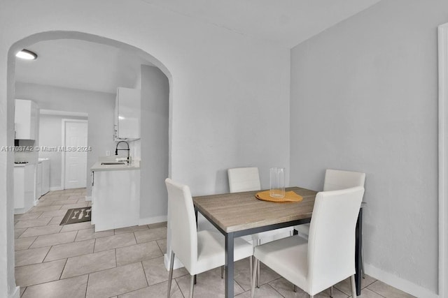 dining space featuring light tile patterned flooring and sink