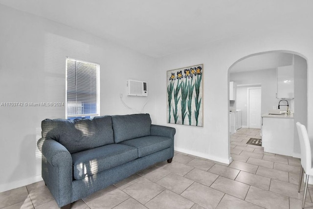 tiled living room with a wall mounted air conditioner and sink