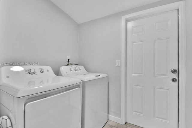 clothes washing area featuring washing machine and dryer and light tile patterned flooring