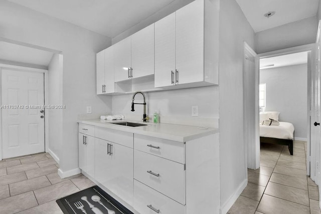 kitchen with sink, white cabinets, and light tile patterned floors