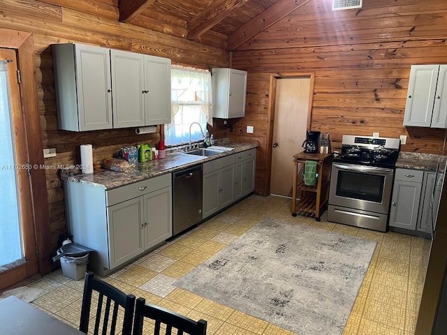 kitchen with wood walls, wooden ceiling, sink, vaulted ceiling with beams, and stainless steel appliances