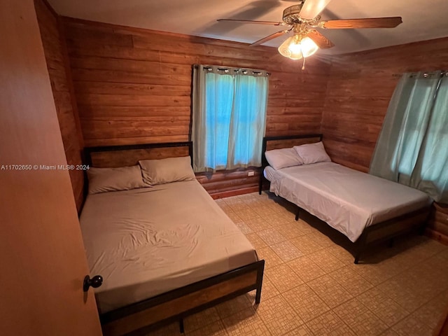 bedroom with rustic walls and ceiling fan