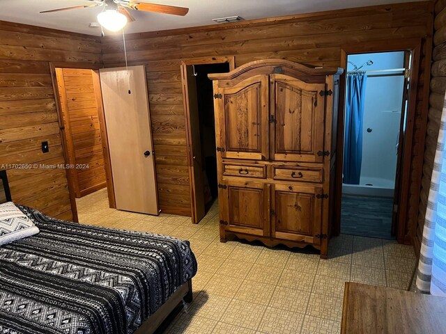 bedroom featuring ceiling fan and wood walls