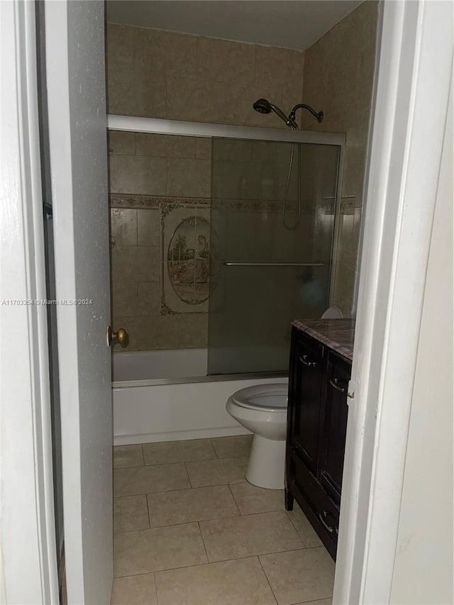 full bathroom featuring tile patterned floors, shower / bath combination with glass door, vanity, and toilet