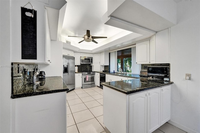 kitchen featuring a tray ceiling, white cabinetry, sink, and black appliances