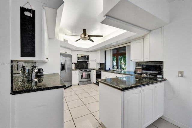 5650 SW 5th St, Plantation, FL 33317 - kitchen with stainless steel appliances, a peninsula, tasteful backsplash, white cabinets, and a ceiling fan