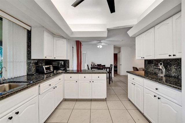 kitchen featuring white cabinetry and dark stone counters