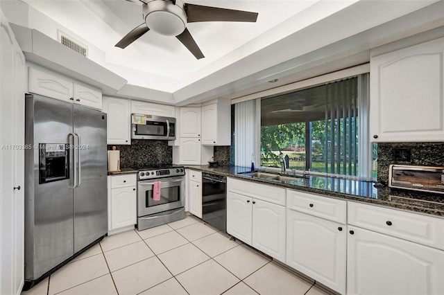 kitchen with white cabinets, sink, appliances with stainless steel finishes, and dark stone counters