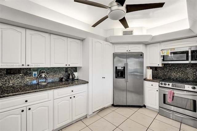 kitchen featuring backsplash, stainless steel appliances, white cabinetry, and dark stone counters