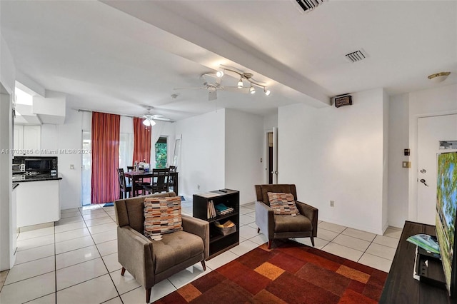 tiled living room with beamed ceiling and ceiling fan