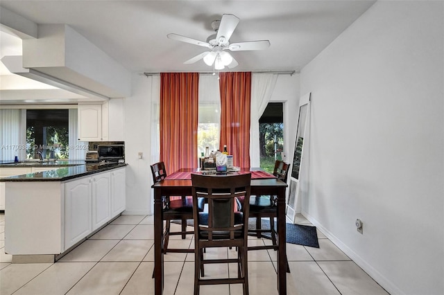 tiled dining space featuring ceiling fan and sink