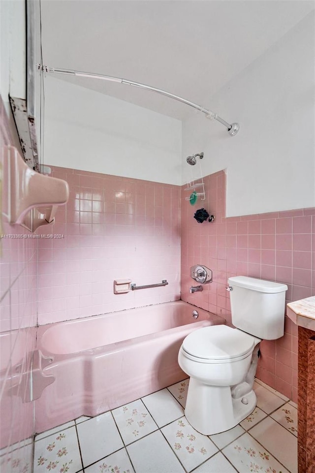 full bathroom featuring tile patterned floors, toilet, tile walls, and tiled shower / bath