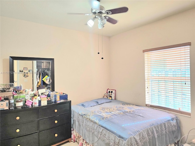 bedroom featuring multiple windows, ceiling fan, and a closet