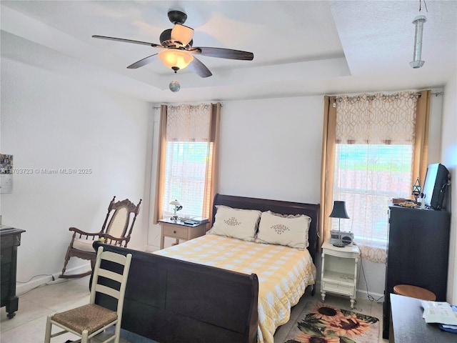 bedroom featuring ceiling fan and a tray ceiling