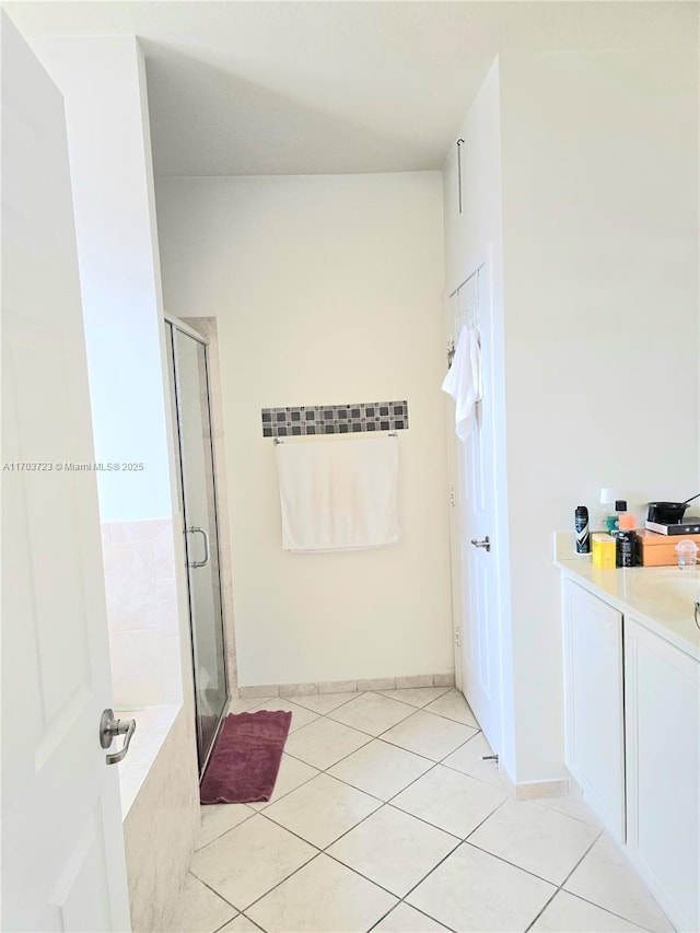 bathroom featuring tile patterned flooring, vanity, and separate shower and tub