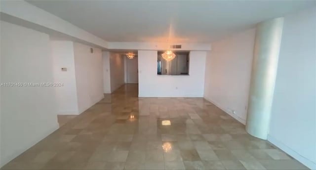 unfurnished room with an inviting chandelier