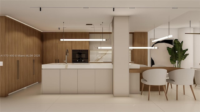 kitchen with tasteful backsplash, wooden walls, brown cabinetry, and light countertops