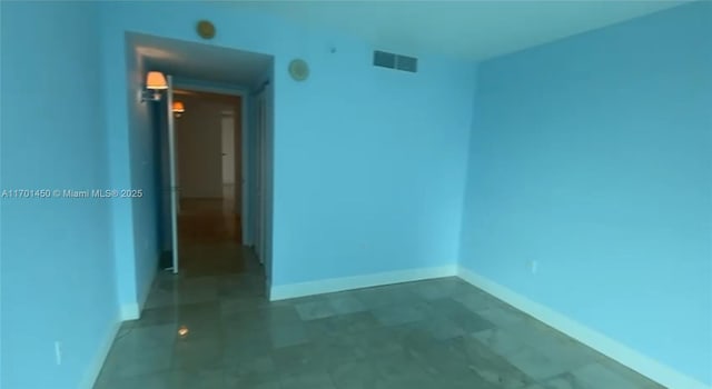 spare room featuring visible vents and baseboards