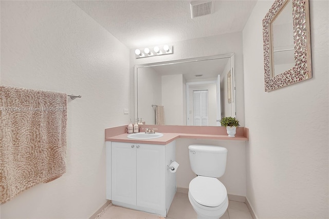 bathroom with vanity, a textured ceiling, toilet, and tile patterned flooring