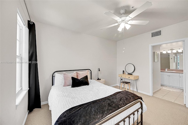 carpeted bedroom with ceiling fan, sink, and ensuite bath