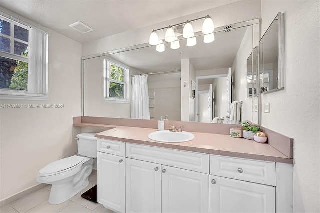 bathroom featuring tile patterned flooring, vanity, toilet, and walk in shower