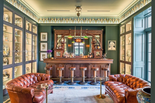 bar featuring crown molding and hanging light fixtures