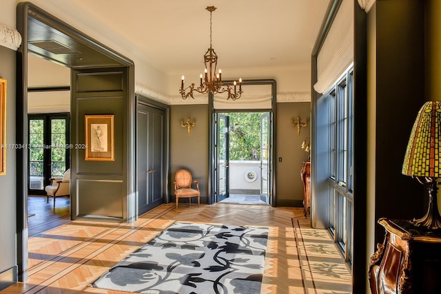 entryway featuring light parquet floors, a healthy amount of sunlight, and an inviting chandelier