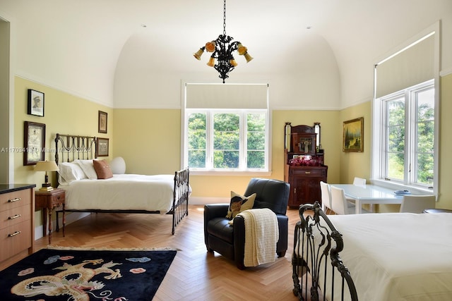 bedroom featuring a towering ceiling, light parquet floors, and an inviting chandelier