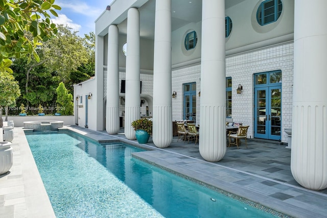 view of swimming pool featuring french doors and a patio