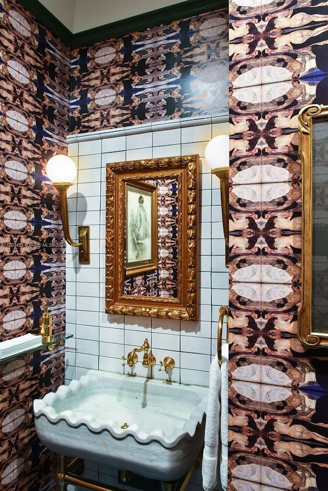 bathroom featuring sink and tile walls